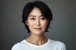 © letter - studio portrait of a person with short dark hair wearing a white t-shirt against a neutral gray background, calm and contemplative mood
