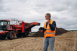 © standret - Conversation by walkie talkie. Farmer is working in the agricultural field. Against beet harvester