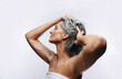 © Jacob Lund - Mature woman washing hair in studio with towel