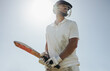 © Jacob Lund - Male cricket player holding a bat under clear skies during a game