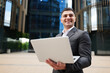 © muse studio - Man works on laptop outside modern office building during daytime in the city