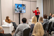 © Anton Gvozdikov - Business conference presentation, speaker addressing seated audience in small professional meeting room, focused discussion and networking atmosphere.