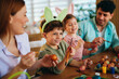 © djile - Family painting easter eggs wearing bunny ears having fun