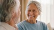 © Rohit k  - Two older adults share a conversation in a bright living room during the afternoon light with smiles and attentive expressions while sitting close together