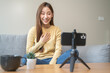 © Pormezz - Young asian woman recording herself interview video via smartphone for her vlog.