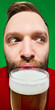 © master1305 - Bearded man holding large glass of beer close up portrait against green background. Concept of bar advertising, beverage branding, festival marketing and hospitality promotion.