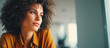 © Jesmine Sulthan - Portrait of a confident young woman with curly hair looking away thoughtfully in a modern indoor setting, lifestyle and career concept.