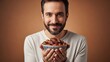 © Dua9Agency - Smiling man holding a bowl of dates with a warm and inviting expression against a neutral background.
