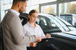 © Serhii - Customer signing car purchase agreement with saleswoman