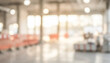 © al-sultan - Blurred interior of an industrial space with bright lights and orange barriers. The scene depicts a modern environment under construction or renovation.