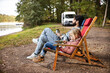 © minamoto images/Stocksy - Father and Daughter Relaxing in Sun Chairs Nearby a Lake