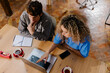 © Adrian Rodd/Stocksy - Top-down view of independent workers reviewing content on a computer