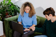© Adrian Rodd/Stocksy - A freelance couple discussing a project, sitting on a sofa