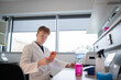 © Hernandez & Sorokina/Stocksy - Scientist Using Phone in Modern Lab Workspace