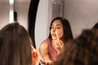 © VICTOR TORRES/Stocksy - Woman applying makeup in front of a mirror