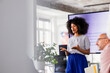 © OchreOchre/Stocksy - Female Presenter Leads Office Presentation In Modern Meeting