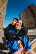 © Javier Díez/Stocksy - Two people share a hug in a city setting on a sunny day