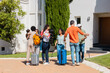 © VICTOR TORRES/Stocksy - Family reunion with hugs and luggage near a house