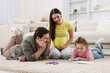 © New Africa - Pregnant woman, her husband and daughter drawing together on floor at home