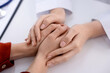 © New Africa - National health service (NHS). Doctor supporting her patient during appointment at white desk, closeup