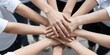 © Studicon - Diverse team members join hands together in a display of unity and collaboration