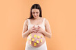 © New Africa - Pregnant woman with notes with different names on her belly against orange background