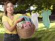 © New Africa - Happy woman with laundry basket near clothes drying outdoors
