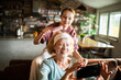 © Geber86 - Granddaughter combing grandmother?s hair during home spa selfie in kitchen