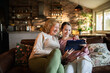 © Geber86 - Grandmother and teenage granddaughter using tablet on sofa at home