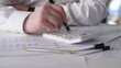 © bisonov - Focused Hands Entering Numbers On Calculator Amid Tax Forms And Receipts, Tense Filing Preparation With Pen And Stacked Documents, Deadlinedriven Accounting