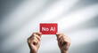 © rakin - Hands firmly hold a bright red card displaying the clear message 'No AI'.