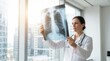 © 5 Grace Media - Female doctor examining patients chest x-ray in modern hospital office.