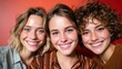 © senadlife - Three cheerful young women pose closely together against a vibrant red backdrop, showcasing friendship and joy in a captivating and lively atmosphere.