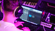 © Pavel - Young Producer Focuses Editing Track, Headphones On. Neon Studio Light, Digital Music Creation, Modern Workflow. Recording studio.