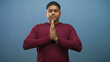© Krakenimages.com - Man with hands pressed together praying in studio, eyes closed and wearing maroon sweater; calm reflection.