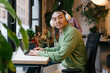 © Westend61 - Worker with headphones using laptop at modern office desk