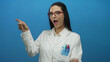 © Krakenimages.com - Woman scientist in a lab coat with red glasses points to the side, standing against a vibrant blue wall, expressing surprise and enthusiasm, conveying a sense of discovery.