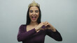 © Krakenimages.com - Woman with crown making heart gesture against white background displaying happiness, beauty, and confidence in a serene, minimal indoor setting.