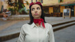 © Krakenimages.com - Flight attendant woman in uniform looks weary on an outdoor street, surrounded by blurred buildings and people, capturing a moment of fatigue and contemplation.