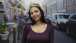 © Krakenimages.com - Young woman with crown smiles confidently on a busy urban street, capturing the lively atmosphere of outdoor city life.