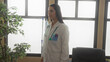 © Krakenimages.com - Young hispanic woman doctor in uniform with stethoscope examines medicine bottles in hospital clinic room surrounded by medical supplies and equipment indoors during work.