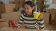 © Krakenimages.com - Woman relaxing in new home holding yellow mug and smartphone surrounded by moving boxes suggests fresh start indoors capturing a moment of tranquility happiness and comfort.
