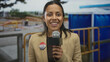 © Krakenimages.com - Young hispanic woman holding microphone with i voted badge at construction site outdoors in usa conducting a report