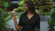© Krakenimages.com - Woman points finger to building in park, smiling with braided hair and black polo shirt; invitation confidence.