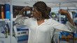 © Krakenimages.com - African american woman flexes arms and smiles on a terrace building dining area with umbrellas and tables; confidence empowerment.