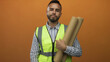 © Krakenimages.com - Man engineer holding rolled blueprints making ok sign with hand in orange studio; confidence reliability teamwork.