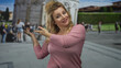 © Krakenimages.com - Woman presenting with open hands at building near the leaning tower of pisa, outdoors; friendly tourist joy.
