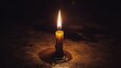 © Yuka - tallow. A short candle with a flickering flame and melted wax on a dark surface. symbolizing life milestones and joyful moments.