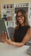 © Krakenimages.com - Woman holds tablet with hand touching screen and smiles while seated in a building with bookshelf; confidence productivity.
