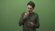 © Krakenimages.com - Man holding smartphone and brownie, finger to lips gesture while scrolling on screen in studio; temptation focus.
